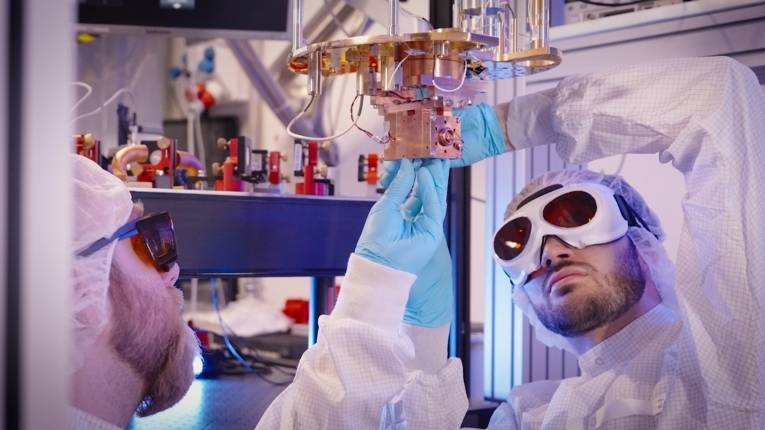 Männer in Schutzkleidung in einem wissenschaftlichen Labor.
